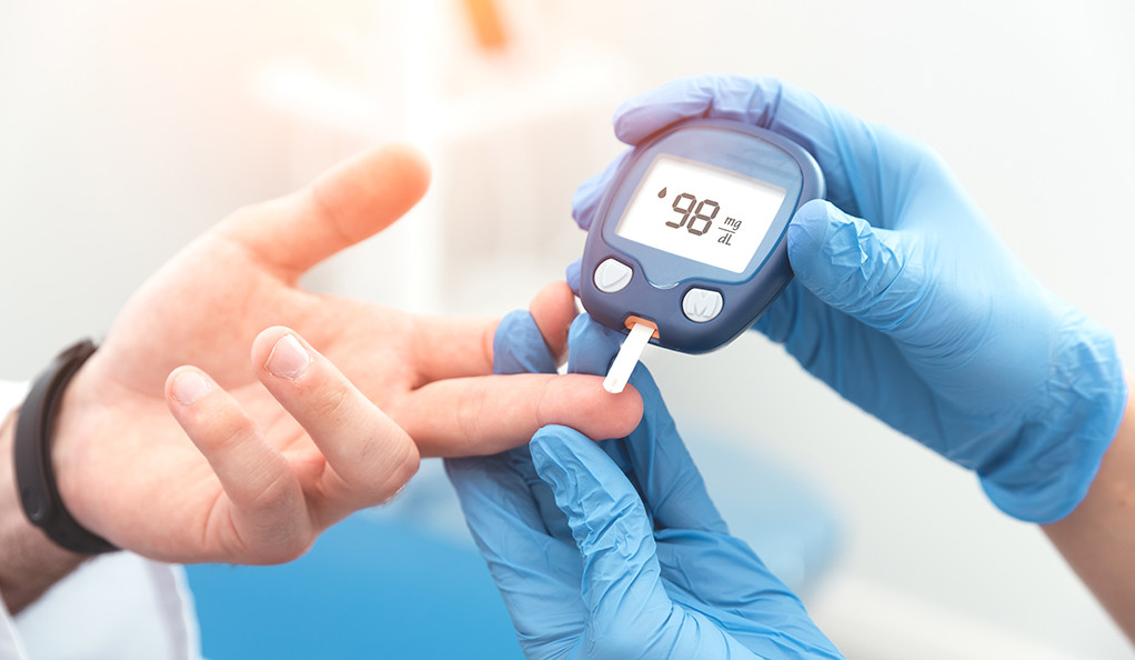 Doctor checking blood sugar level with glucometer. Treatment of diabetes concept.